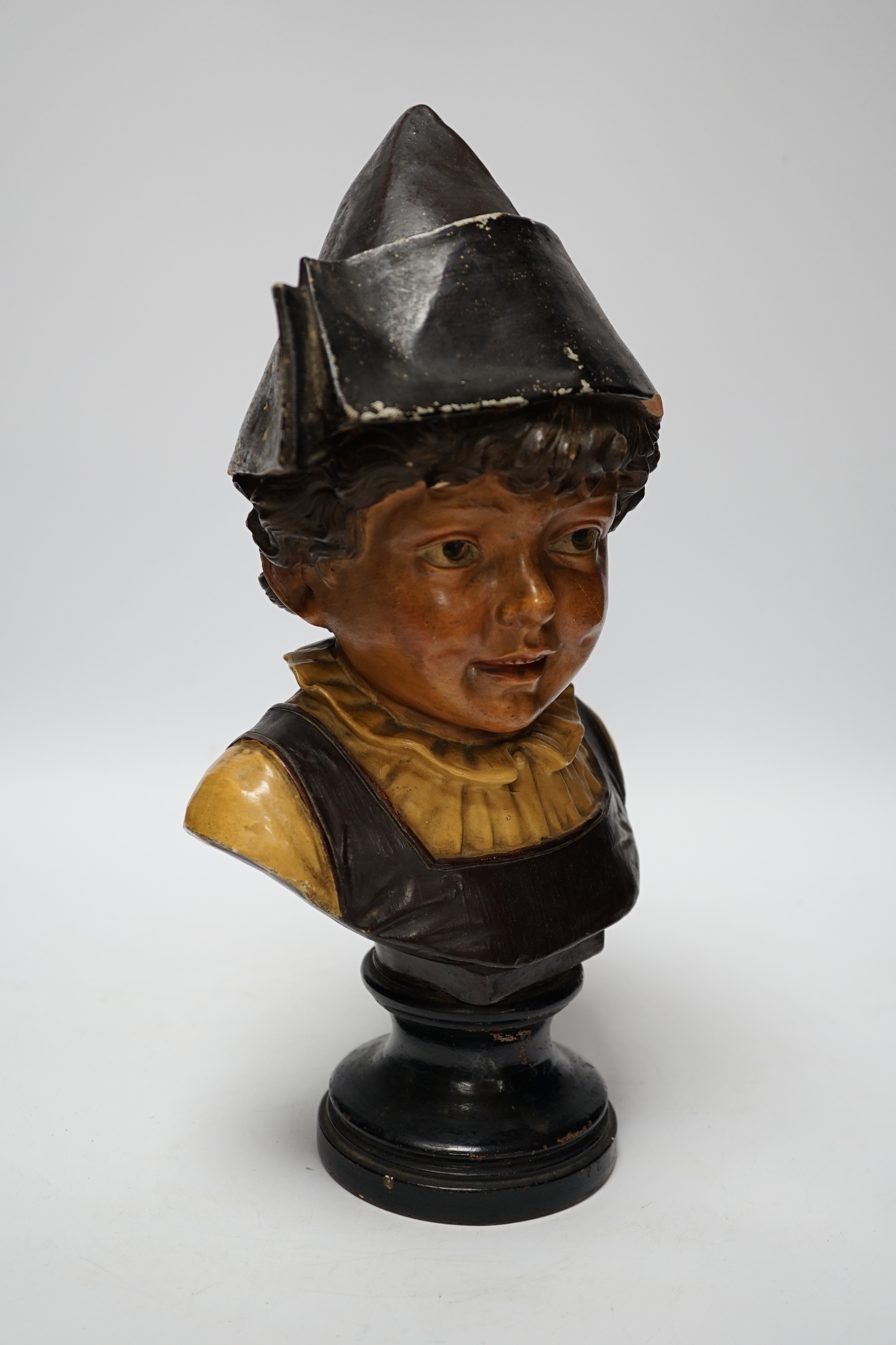 A French cold painted terracotta bust of a child in a bicorn hat on socle plinth, 37cm high